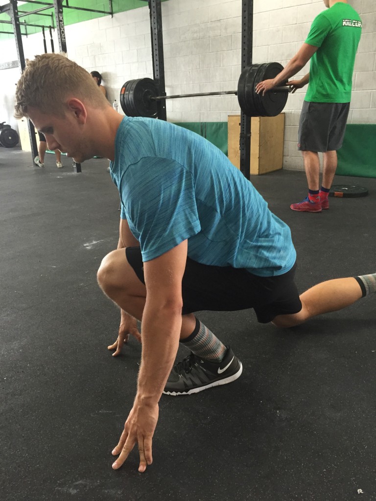 Coach Bryce demonstrating ankle mobility at CrossFit Invictus in San Diego