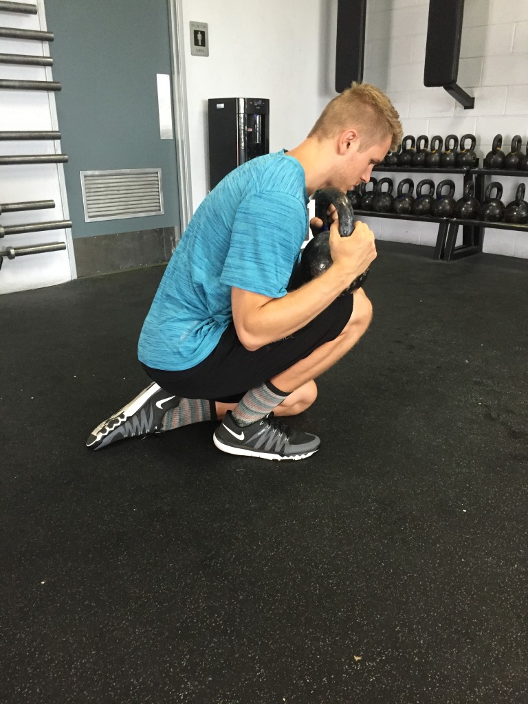 Coach Bryce demonstrating ankle mobility at CrossFit Invictus in San Diego