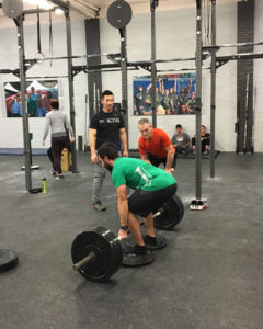 Two athletes give their training partner cues on his deadlift.