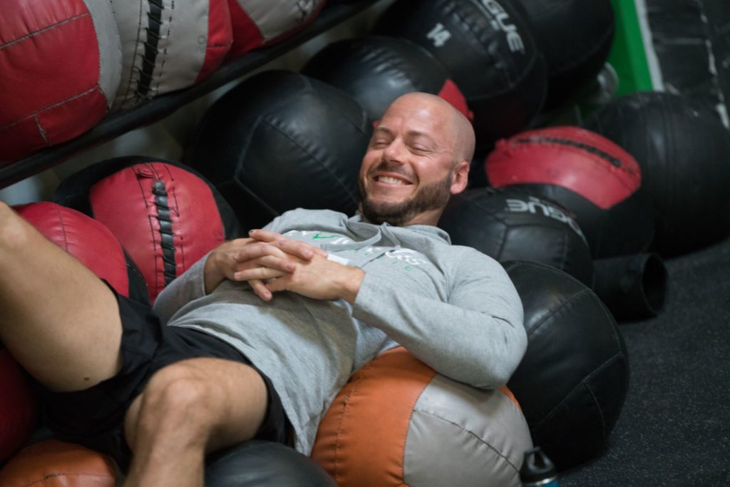 A male athlete presents to sleep in a pile of medicine balls.