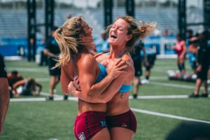 Two female athletes hugging each other in celebration.