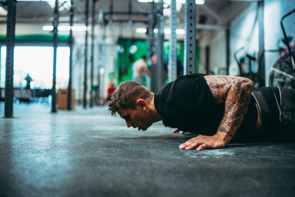 Man Doing Burpees in a Crossfit Gym