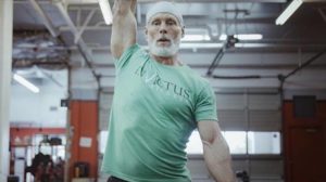 Invictus Masters Athlete - Kevin Koester - doing a single-arm dumbbell snatch.