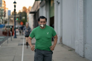An Invictus gym member running around the block during a workout.