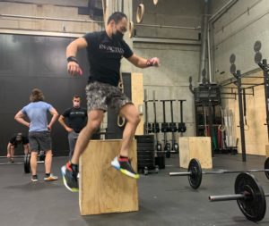 A male athlete jumping down of a 30-inch box.