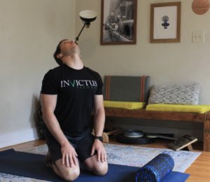 Male athlete doing neck stretches in his living room.