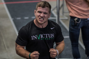 Invictus Athlete-Coach, Ricky Moore, clinches his fists in celebration while making a "lets go" face.