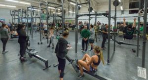 Athletes warming up for the CrossFit Open while over a hundred onlookers watch during Friday Night Lights at the gym.