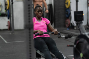 Female athlete rowing during a class at the gym.