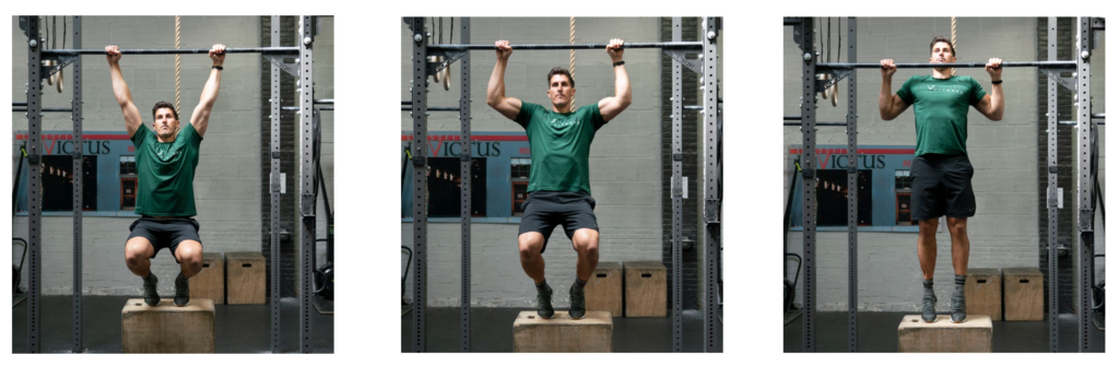 Male athlete using a box for assisted tempo pull-ups.