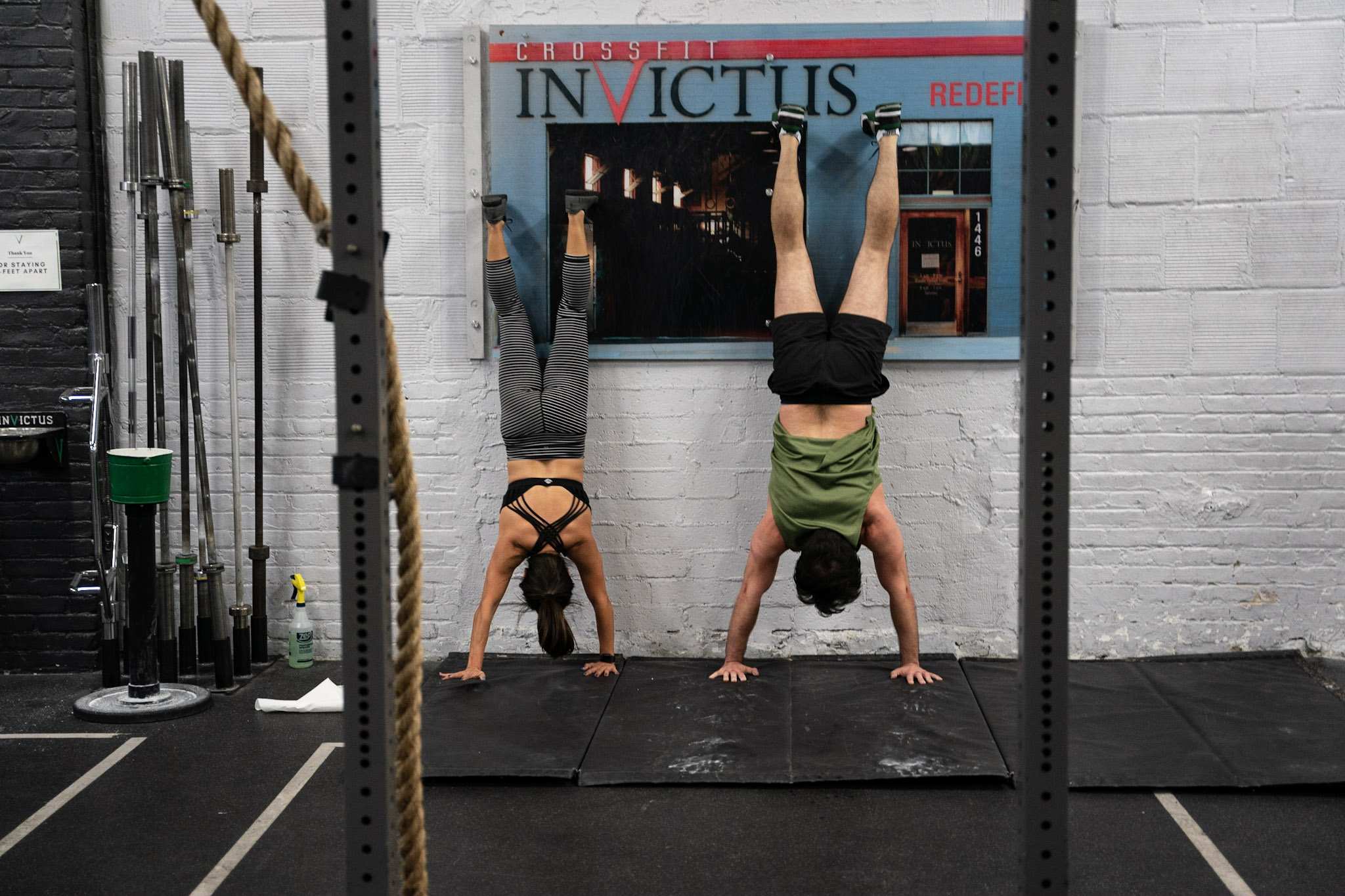 Athletes doing nose to wall handstand holds as a part of their CrossFit Open prep.