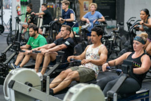 Group of athletes at the gym on rowing machines.