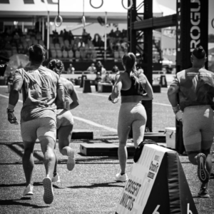 Three athletes running away from the camera as they start an event at the CrossFit Games.