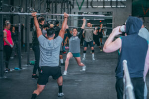 Invictus Athlete Camp attendees practice the timing of receiving the bar during a weightlifting drill session.