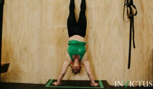 Invictus athlete doing perfect handstand push-ups because she enrolled in Invictus Gymnastics.