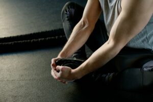 Man stretching his sore muscles because he didn't read this article before working out.