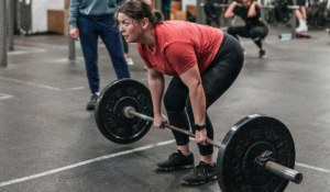 Female Invictus athlete pulling the barbell from the floor