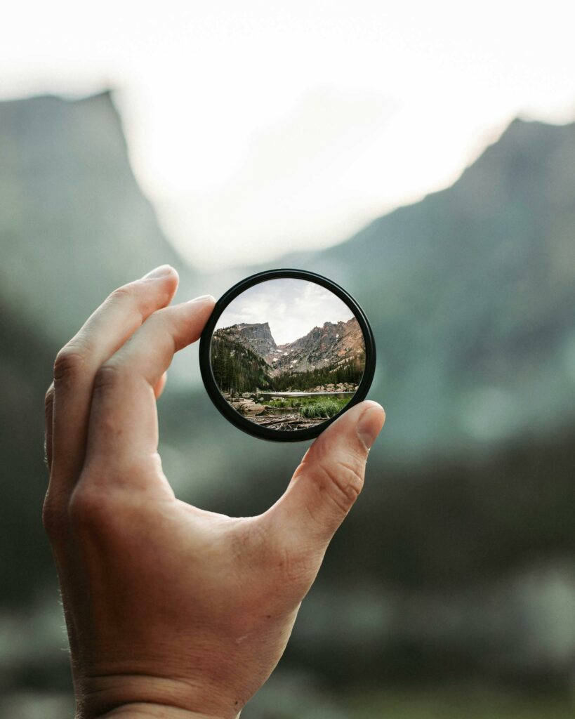 Someone looking at a mountain through an eye glass and just being curious! 